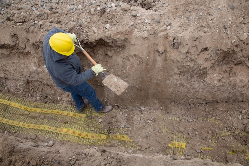 Worker digging in trench