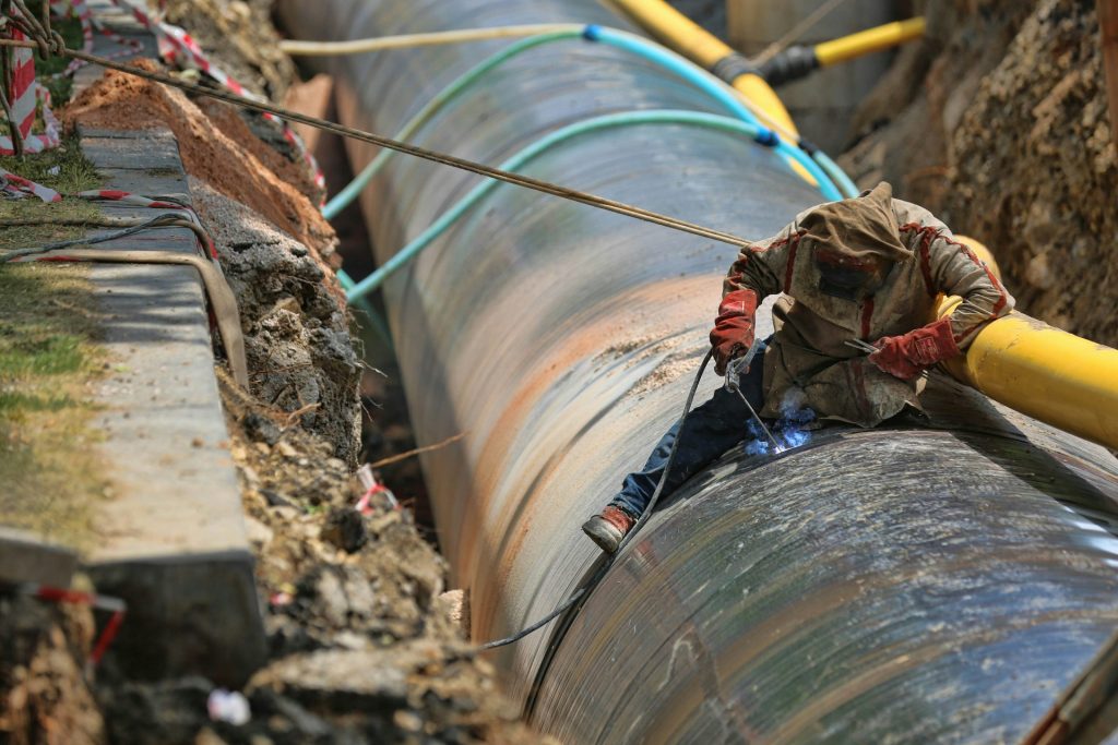 Worker repairing large pipeline