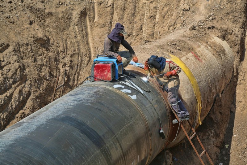 Workers repairing a large pipeline